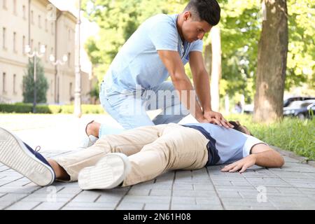 En effectuant une RCP sur un jeune homme inconscient à l'extérieur. Premiers soins Banque D'Images