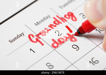 Femme marquant la date du jour de la marmotte dans le calendrier, clôture Banque D'Images