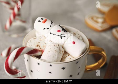 Bonhomme de neige en guimauve amusant dans une tasse de boisson chaude, en gros plan Banque D'Images