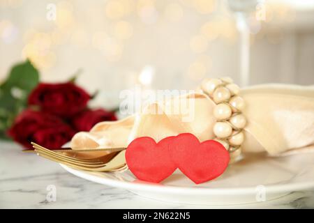 Table élégante pour un dîner romantique avec des lumières de fête floues. Célébration de la Saint-Valentin Banque D'Images