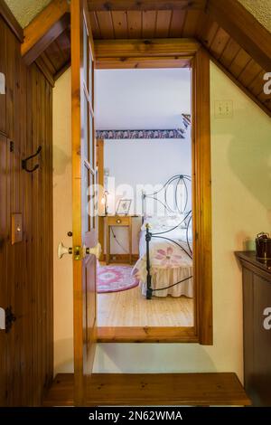 En regardant par la porte ouverte de la salle de bains attenante dans la chambre principale à l'étage à l'intérieur de la vieille maison de 1927. Banque D'Images