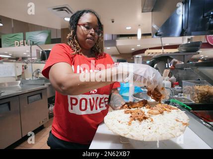 Des Peres, États-Unis. 09th févr. 2023. La chef adjointe Carrie Frost place des morceaux de poulet au bar-barbecue sur une pizza au fromage lors de la Journée nationale de la pizza aux marchés de Schnucks à des Peres, Missouri, jeudi, 9 février 2023.photo par Bill Greenblatt/UPI crédit: UPI/Alamy Live News Banque D'Images