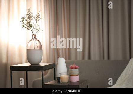Diffuseur d'huile aromatique et bougie sur table dans la chambre Banque D'Images