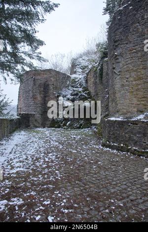 Falkenstein, Allemagne - 31 janvier 2021: Côté des ruines du château de Falkenstein et mur lors d'une journée d'hiver enneigée à Rheinland Pfalz, Allemagne. Banque D'Images