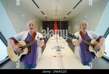 Hambourg, Allemagne. 09th févr. 2023. Stefanie Ansul-Weissner, une femme de ménage de STR Stadtteilreinigungsgesellschaft mbH, joue sa guitare et chante une chanson dans les toilettes publiques de Am Niederhafen. À Hambourg, sur la promenade de l'Elbe, il y a un petit endroit tranquille qui n'est pas du tout si calme, grâce à un gardien de toilettes musicales, et qui est également de bonne humeur. (À dpa: 'Bonne humeur en faisant wee-wee - la femme de toilette de Hambourg joue de la guitare') Credit: Marcus Brandt/dpa/Alamy Live News Banque D'Images