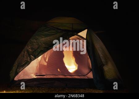 Camping romantique. Vue sur la silhouette d'un jeune couple embrassant dans une tente. Banque D'Images