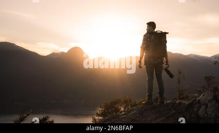 homme debout au sommet de la montagne pendant le coucher du soleil Banque D'Images