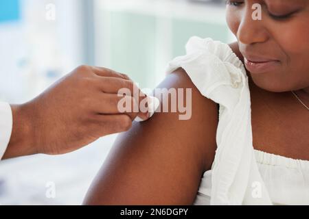 Médecin nettoyant le bras du patient avant l'injection. main d'un médecin utilisant un coton-tige pour nettoyer le bras d'un patient. Patient pendant une vérification dans le Banque D'Images