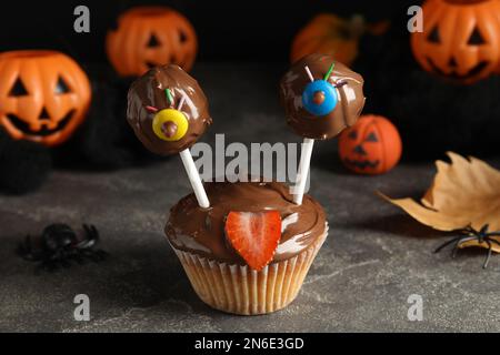 Délicieux desserts décorés comme des monstres sur une table grise. Halloween Banque D'Images