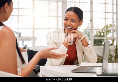 Deux jeunes femmes d'affaires de race mixte et heureuses rient tout en ayant une réunion dans une salle de réunion au travail. Des hommes d'affaires joyeux parlent pendant la planification Banque D'Images