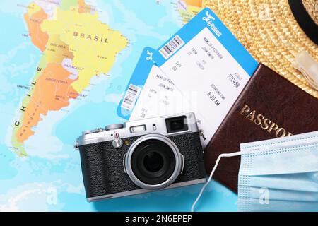 Composition de pose plate avec passeport et masque de protection sur la carte du monde. Voyage pendant la quarantaine Banque D'Images