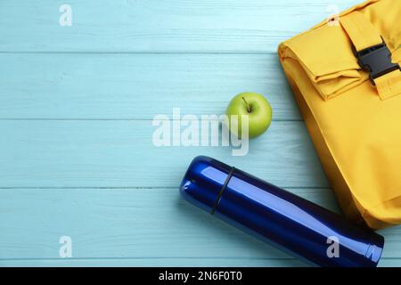 Composition de pose plate avec thermos sur fond en bois turquoise, espace pour le texte Banque D'Images