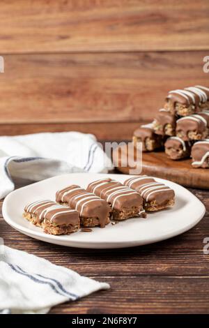 Biscuits enrobés de chocolat. Produits de boulangerie. Biscuits au chocolat sur fond de bois. gros plan Banque D'Images