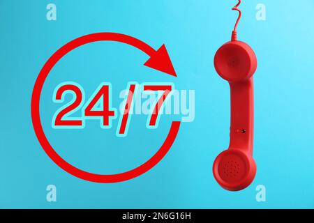 service d'assistance téléphonique 24h/24/7, 7j Combiné rouge sur fond bleu Banque D'Images