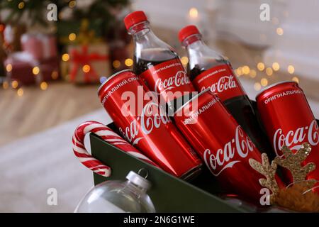 MYKOLAIV, UKRAINE - 13 JANVIER 2021 : bouteilles et canettes Coca-Cola en boîte, gros plan Banque D'Images