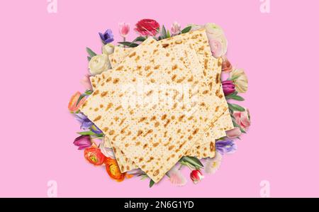 Savoureux matzos et fleurs sur fond rose, plat. Fête de la Pâque (Pesach) Banque D'Images