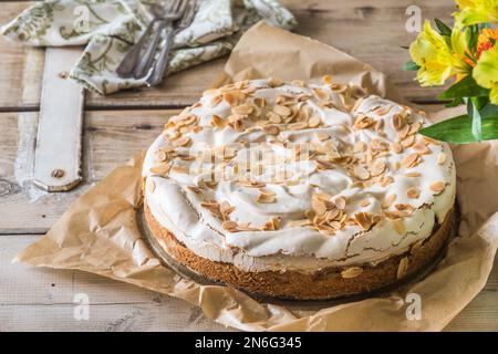 Tarte à la rhubarbe avec garniture meringue et amandes grillées sur une ancienne table rustique en bois Banque D'Images