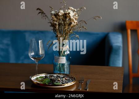 Un morceau de saumon grillé poivre citron et sel sur une assiette brune avec des feuilles de laitue. arrière-plan en bois. Photo de haute qualité Banque D'Images