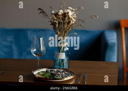 Un morceau de saumon grillé poivre citron et sel sur une assiette brune avec des feuilles de laitue. arrière-plan en bois. Photo de haute qualité Banque D'Images