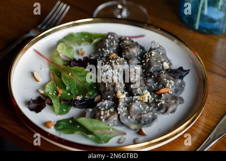 Un morceau de saumon grillé poivre citron et sel sur une assiette brune avec des feuilles de laitue. arrière-plan en bois. Photo de haute qualité Banque D'Images