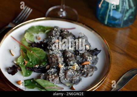 Un morceau de saumon grillé poivre citron et sel sur une assiette brune avec des feuilles de laitue. arrière-plan en bois. Photo de haute qualité Banque D'Images