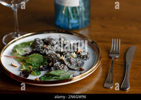 Un morceau de saumon grillé poivre citron et sel sur une assiette brune avec des feuilles de laitue. arrière-plan en bois. Photo de haute qualité Banque D'Images