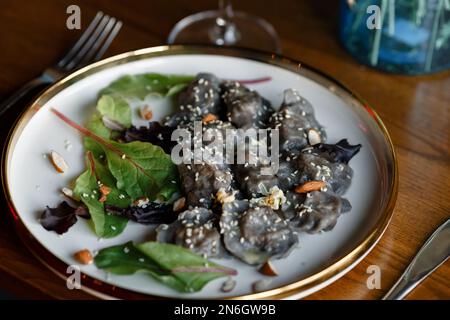 Un morceau de saumon grillé poivre citron et sel sur une assiette brune avec des feuilles de laitue. arrière-plan en bois. Photo de haute qualité Banque D'Images
