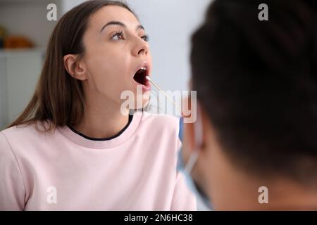 Médecin prenant l'échantillon pour le test d'ADN de la femme en clinique Banque D'Images