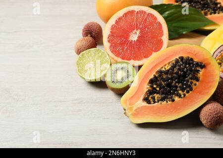 Papaye mûre fraîche et autres fruits sur une table en bois blanc. Espace pour le texte Banque D'Images