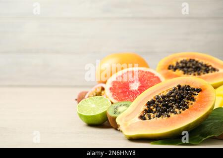 Papaye mûre fraîche et autres fruits sur une table en bois blanc. Espace pour le texte Banque D'Images