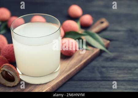 Jus de lychee frais sur table en bois noir. Espace pour le texte Banque D'Images