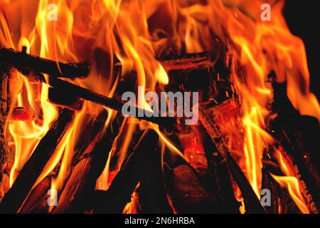 flammes et bois de chauffage brûlant et branches dans une cheminée dans un format de bannière avec flou Banque D'Images
