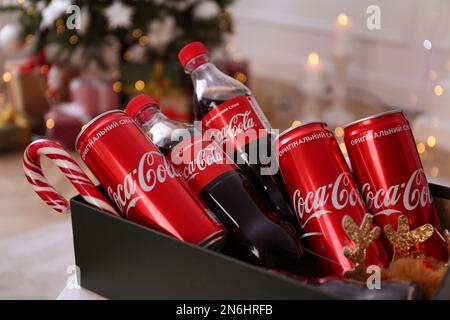 MYKOLAIV, UKRAINE - 13 JANVIER 2021 : bouteilles et canettes Coca-Cola en boîte, gros plan Banque D'Images