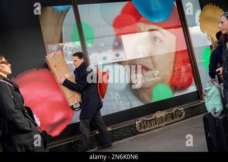 Les membres du public interagissent avec un écran présentant l'artiste Yayoi Kusama dans une fenêtre de Harrods à Knightsbridge, le 9th février 2023, à Londres, en Angleterre. L'artiste inimitable Yayoi Kusama travaille avec Louis Vuitton et leur collaboration est actuellement vue dans les fenêtres de nombreux détaillants qui ont en stock la marque française de bagages et de sacs à main de luxe. Banque D'Images