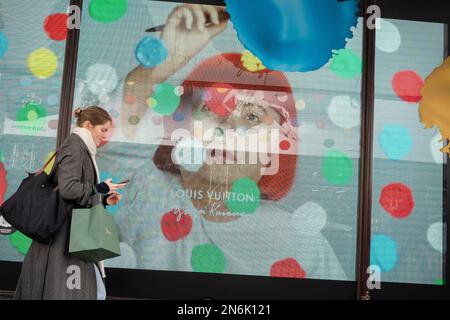 Les membres du public interagissent avec un écran présentant l'artiste Yayoi Kusama dans une fenêtre de Harrods à Knightsbridge, le 9th février 2023, à Londres, en Angleterre. L'artiste inimitable Yayoi Kusama travaille avec Louis Vuitton et leur collaboration est actuellement vue dans les fenêtres de nombreux détaillants qui ont en stock la marque française de bagages et de sacs à main de luxe. Banque D'Images