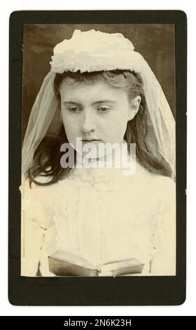 Original victorien CDV de la jeune fille catholique sérieuse en première communion tenue avec voile et adresse, vers 1890 Royaume-Uni Banque D'Images