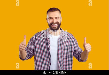 Homme joyeux approuvant, faisant un geste positif de la main, souriant et appréciant le succès. Banque D'Images