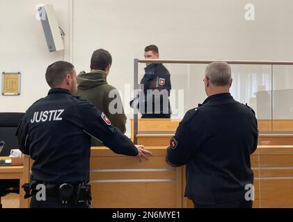 Hanovre, Allemagne. 10th févr. 2023. Le défendeur de 28 ans (2nd de gauche) entre dans la salle d'audience du tribunal régional pour le procès pour double meurtre. L'Allemand est accusé d'avoir poignardé sa mère et son nouveau mari à mort par colère et par déception à cause de créances irtenues. Credit: Christina Sticht/dpa/Alay Live News Banque D'Images