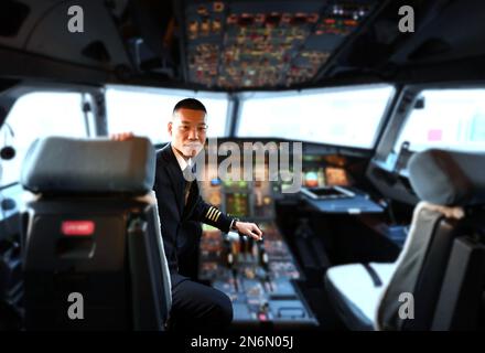 (230210) -- DALIAN, 10 février 2023 (Xinhua) -- Ma Baoli est visible dans le poste de pilotage de Dalian, dans la province de Liaoning, au nord-est de la Chine, 4 février 2023. Le capitaine Ma Baoli, 35 ans, a une grande passion pour les poèmes classiques chinois. À partir de 2018, Ma participe chaque année au Quiz chinois de poésie classique et remporte le championnat cette année.l'amour de Ma pour les poèmes classiques chinois a été nourri par son père depuis son enfance. Diplômé de l'Université d'aéronautique et d'astronautique de Nanjing, Ma a rejoint la branche Dalian de China Southern Airlines et a été promu capitaine en 2016. La passion de ma Banque D'Images