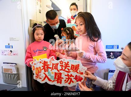 (230210) -- DALIAN, le 10 février 2023 (Xinhua) -- Ma Baoli (2nd L) joue un poème ancien sur le thème du printemps citant un jeu avec des passagers lors d'un vol de Dalian, dans la province de Liaoning, au nord-est de la Chine, à Guangzhou, dans la province de Guangdong, au sud de la Chine, le 4 février 2023. Le capitaine Ma Baoli, 35 ans, a une grande passion pour les poèmes classiques chinois. À partir de 2018, Ma participe chaque année au Quiz chinois de poésie classique et remporte le championnat cette année.l'amour de Ma pour les poèmes classiques chinois a été nourri par son père depuis son enfance. Comme diplômé de l'Université de Nanjing de l'aéronautique et Banque D'Images