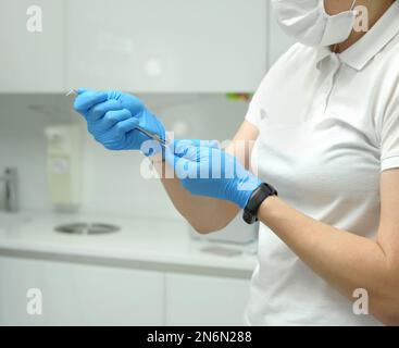 Seringue de carpulse instruments spéciaux utilisés en dentisterie pour l'anesthésie locale main de médecin femelle gants bleus en métal, verre ou plastique et ont une conception simple d'un corps cylindrique et piston Banque D'Images