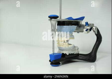 Un articulateur utilisé dans les laboratoires dentaires fixé sur fond blanc articulation dentaire avec modèle de prothèse de gypse dentaire dans les laboratoires dentaires. Photo de haute qualité Banque D'Images