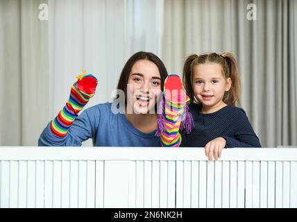 Mère et fille qui exécutent un spectacle de marionnettes à la maison Banque D'Images