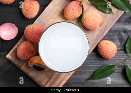 Jus de lychee frais et fruits sur une table en bois noir, plat Banque D'Images