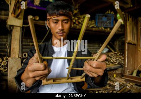 Bandung, Indonésie. 10th févr. 2023. Un ouvrier fabrique un angklung, un instrument traditionnel de musique de bambou à l'atelier de Saung Angklung Udjo à Bandung, West Java, Indonésie, le 10 février 2023. Crédit: Septianjar Muharam/Xinhua/Alamy Live News Banque D'Images