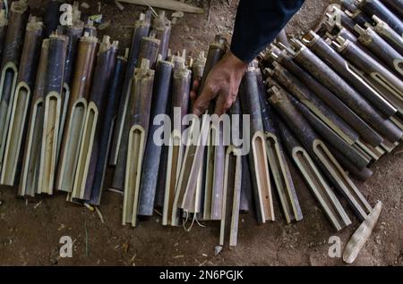 Bandung, Indonésie. 10th févr. 2023. Un travailleur choisit un bambou pour fabriquer un angklung, un instrument traditionnel de musique de bambou à l'atelier de Saung Angklung Udjo à Bandung, West Java, Indonésie, 10 février 2023. Crédit: Septianjar Muharam/Xinhua/Alamy Live News Banque D'Images