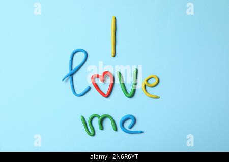 Expression Je m'aime fait de modélisation de l'argile sur fond bleu clair, plat Banque D'Images