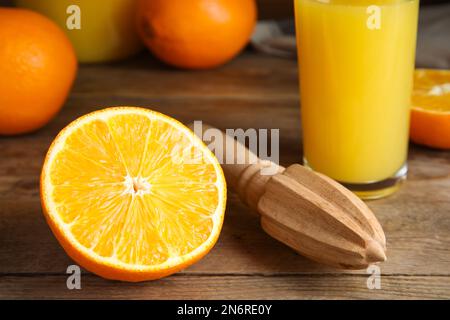 Couper l'orange mûr frais, l'alésoir et le jus sur une table en bois, en gros plan Banque D'Images