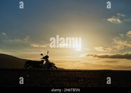 Une silhouette de moto sur une route de montagne Banque D'Images