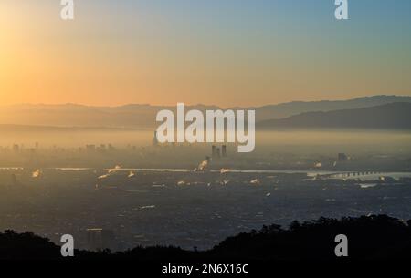 Lever de soleil orange et ciel bleu avec couche de smog sur les gratte-ciel de la ville Banque D'Images